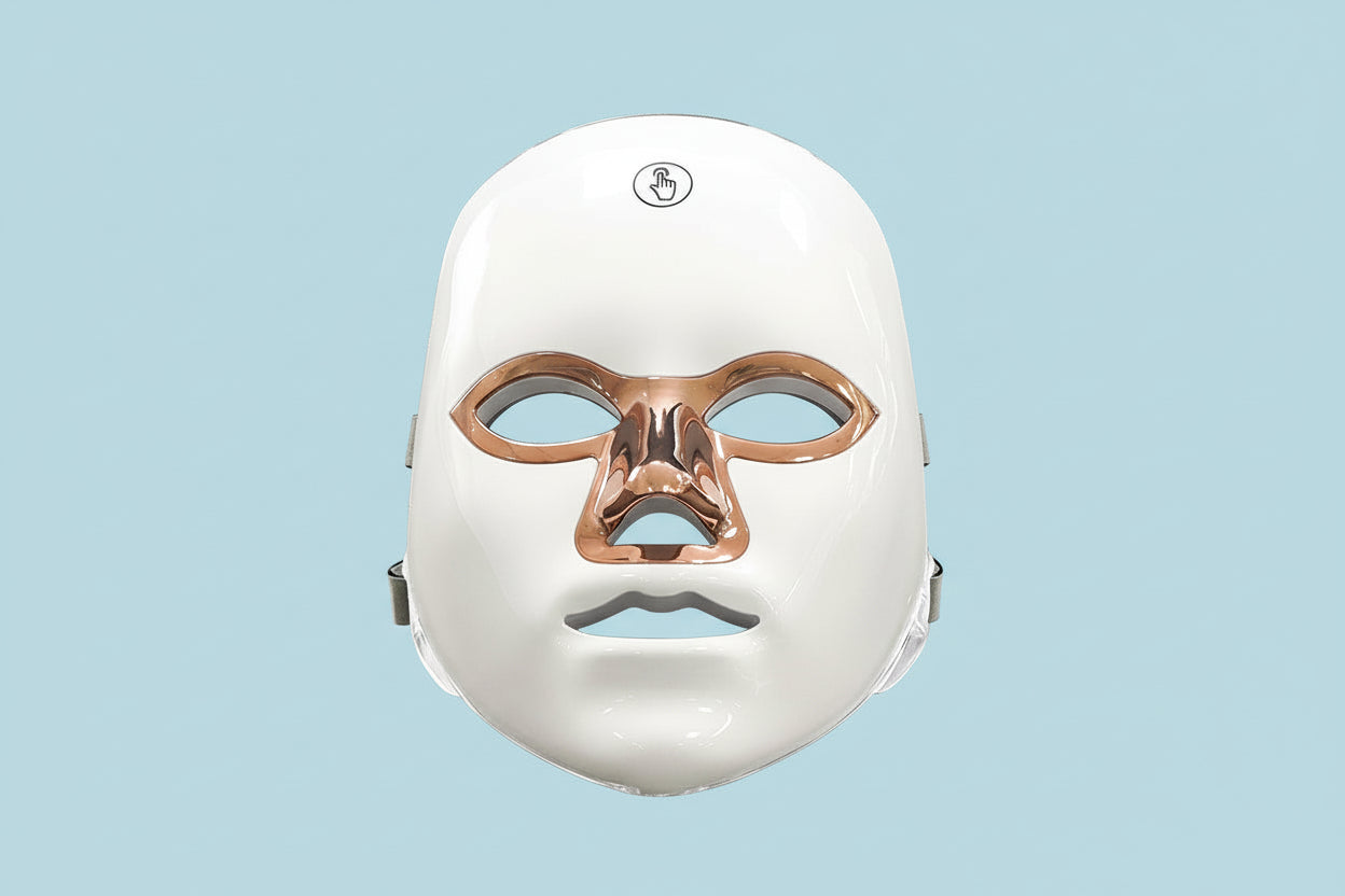 White facial mask with bronze accents on a white background