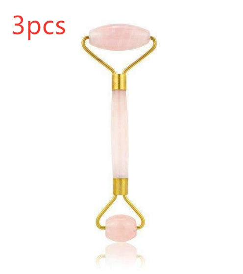 Facial roller with pink stones on a white background