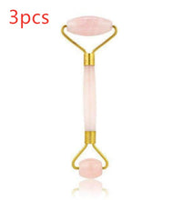 Facial roller with pink stones on a white background