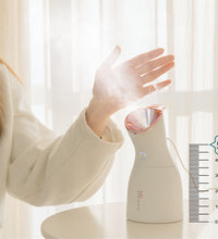 Person using a handheld humidifier with a visible brand logo on a light background
