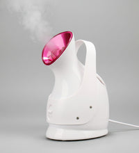White handheld steamer with pink top emitting steam on a black background