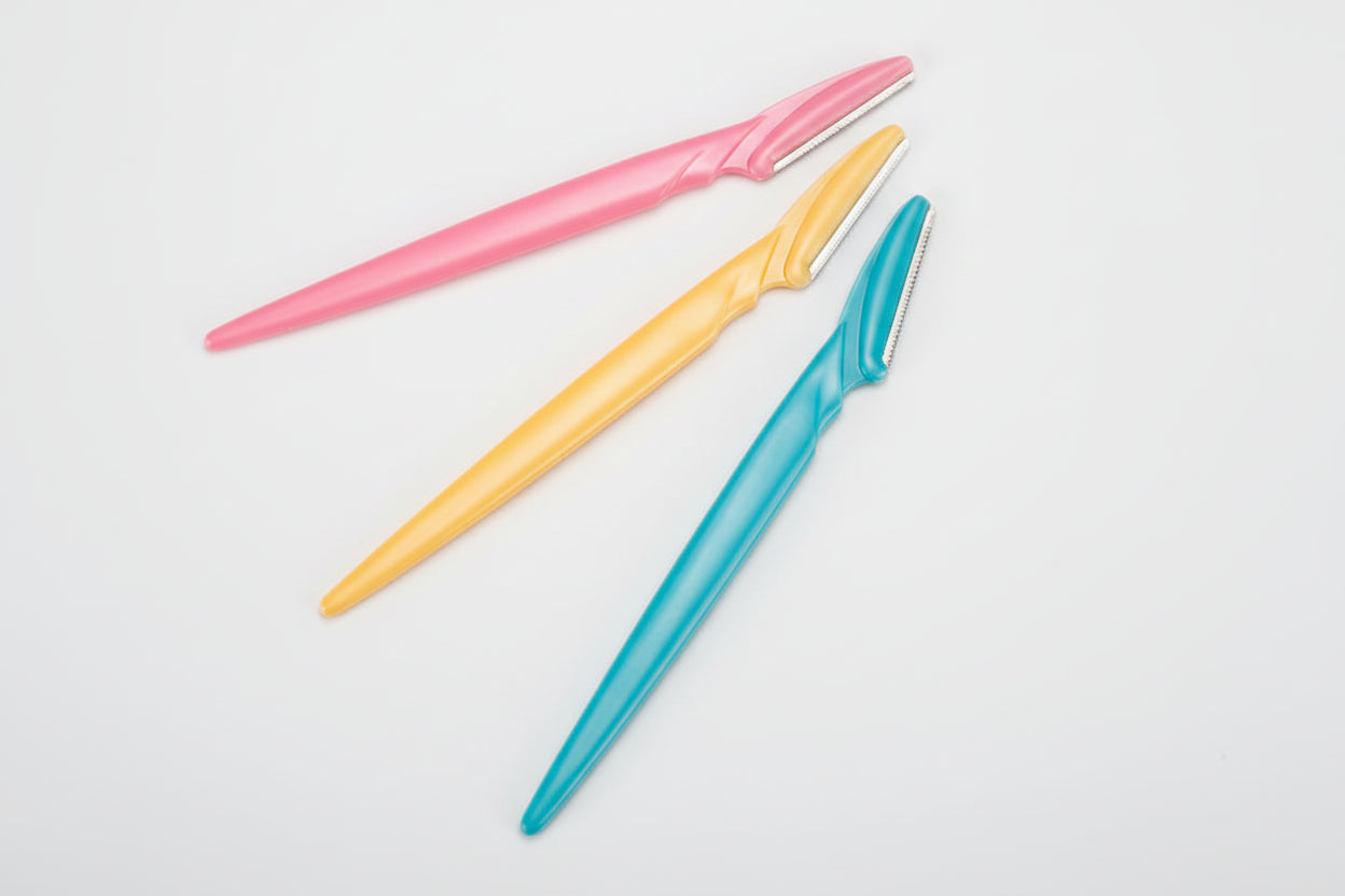 Three colorful razors (pink, yellow, blue) on a white background