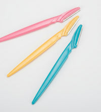 Three colorful razors (pink, yellow, blue) on a white background