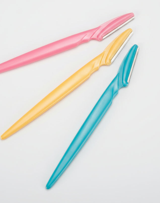 Three colorful razors (pink, yellow, blue) on a white background